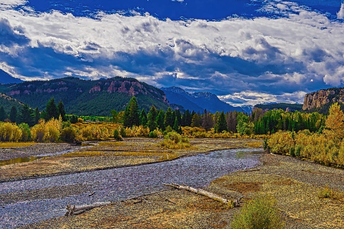 A river in the mountains with a cloudy sky.