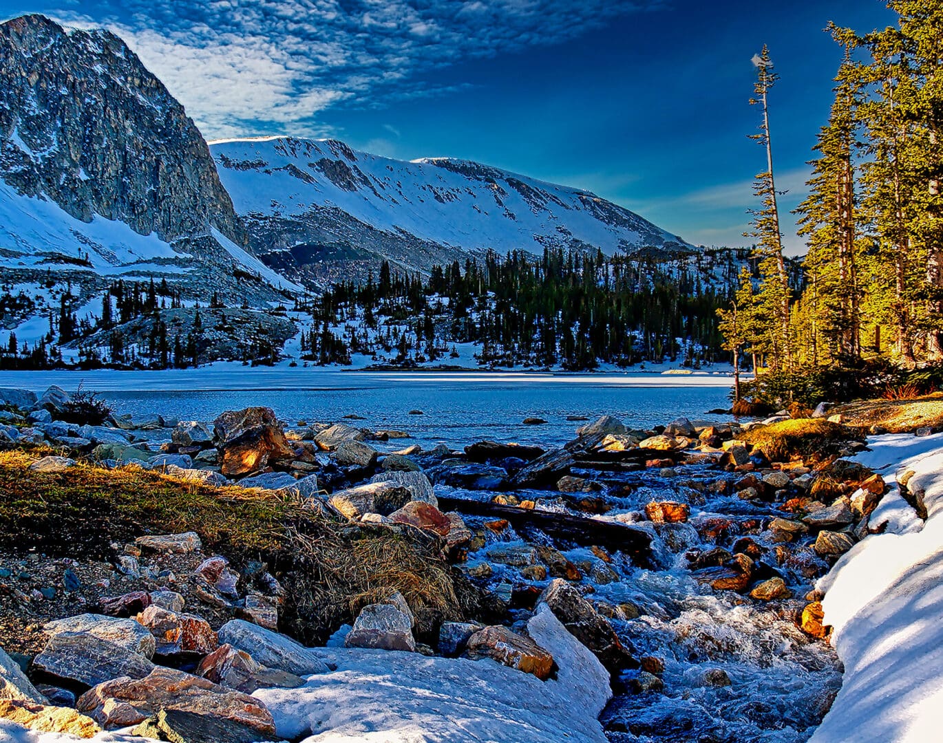 A snow covered mountain with a river running through it.