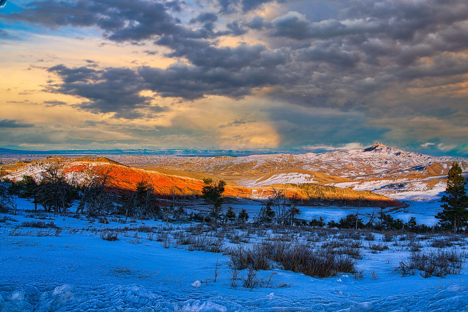 A snow covered landscape with clouds in the sky.