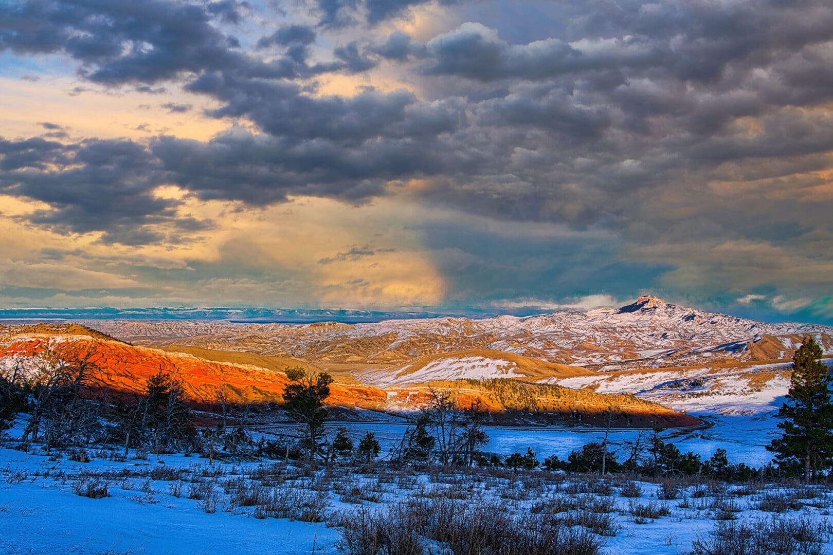 A snow covered landscape with clouds in the sky.