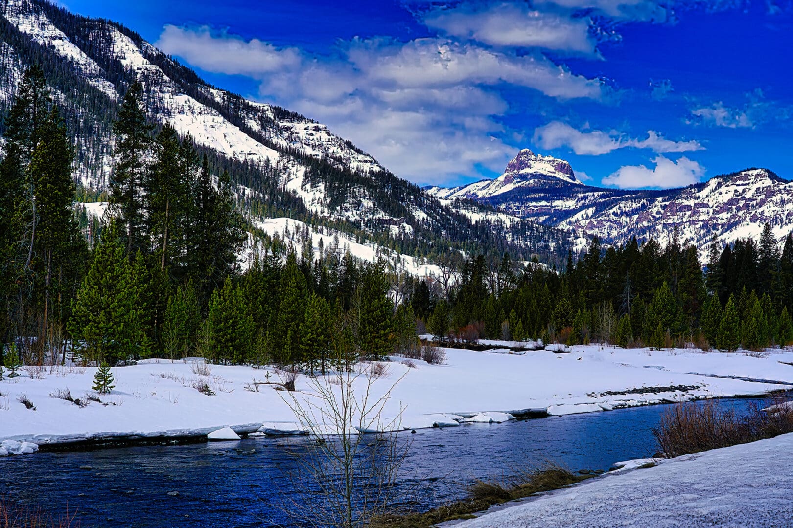 A river in the middle of a snow covered mountain.