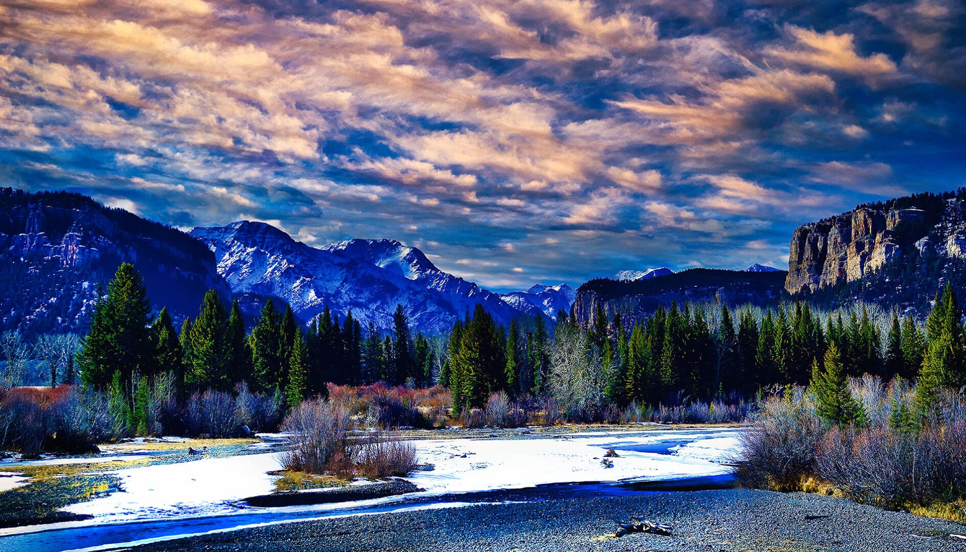 A snowy landscape with trees and a river.