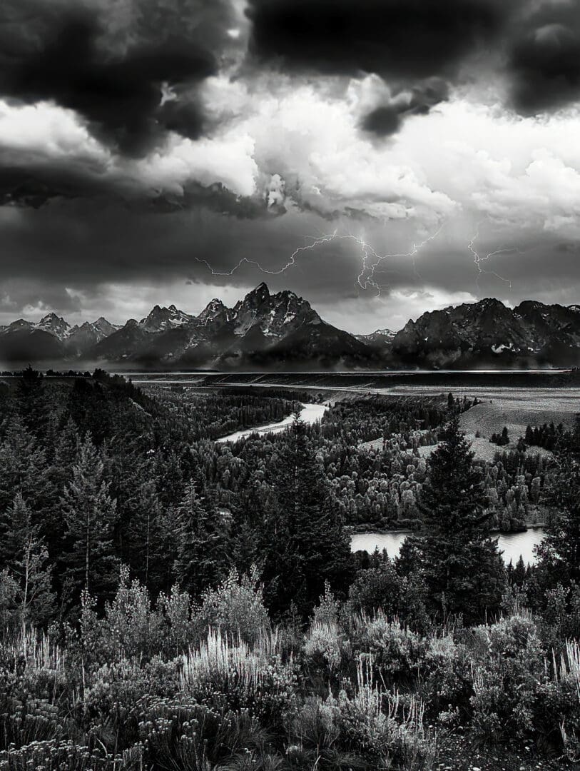 A black and white photo of a stormy sky over the grand teton.