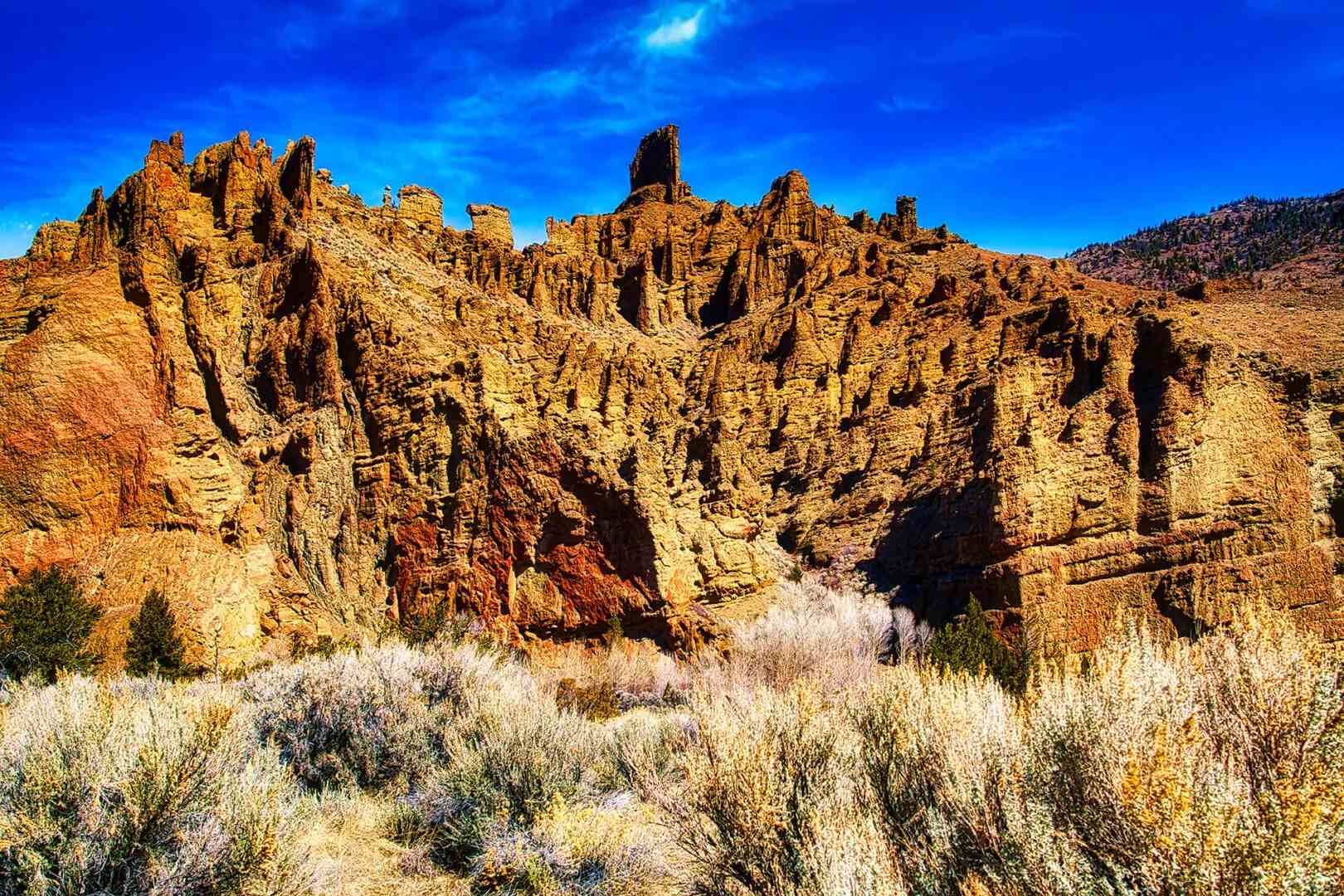 A rock formation in the desert with a blue sky.